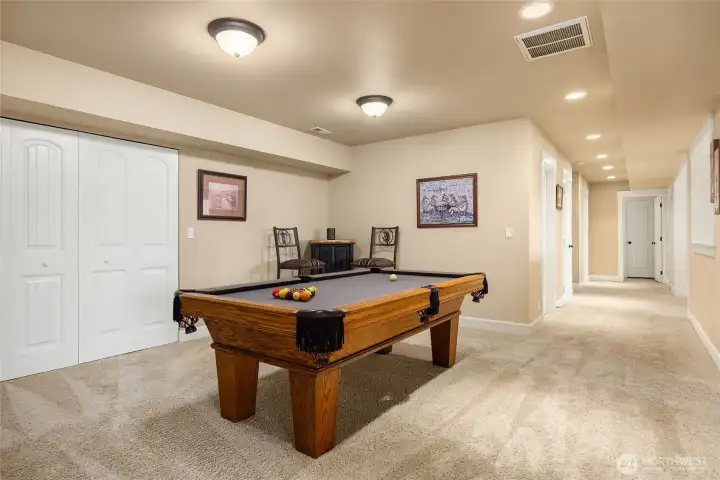 A generous lower-level entertainment space includes a billiards area that extends from the family room, ideal for gatherings and recreation.