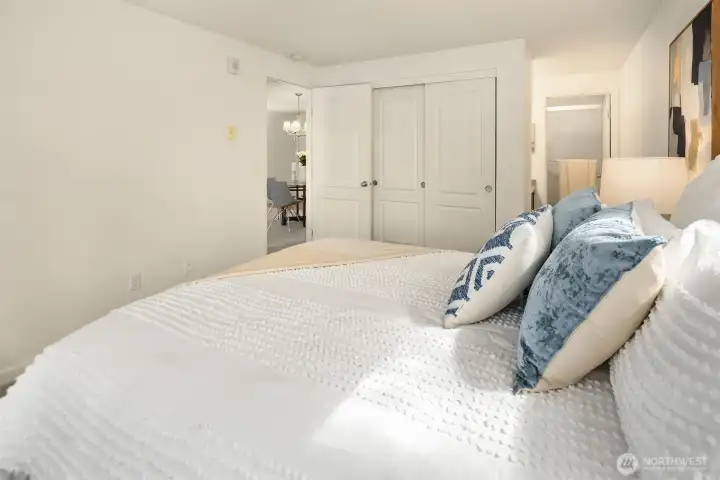 Another view of the primary bedroom showcasing the large three-panel closet and the ensuite bathroom to the right