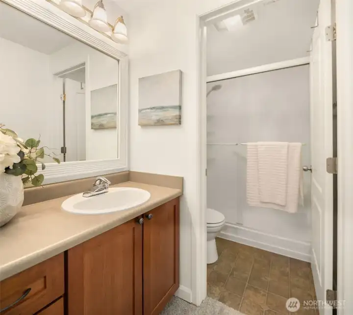Primary bathroom featuring a spacious vanity with cherry cabinets and a separate walk-in shower