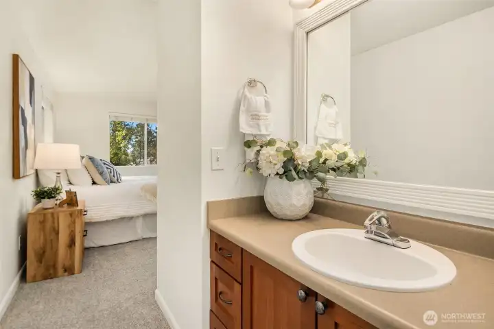 Perspective from the primary bathroom vanity into the primary bedroom, highlighting the connected layout