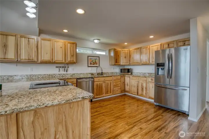 Granite countertops and stainless steel appliances highlight the kitchen.