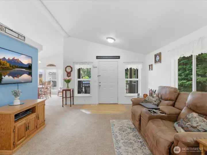 Vaulted ceilings in the living room, kitchen, dining room. Trees out the window give privacy in the living space.