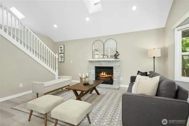 Enter into the Living Room/Great Room area with vaulted ceiling, skylights & large windows, and a neutral palette.