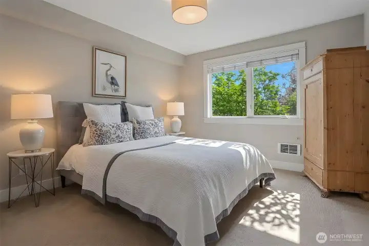 Primary bedroom with southern exposure and serene views of mature trees. Primary bedroom with southern exposure and serene views of mature trees.