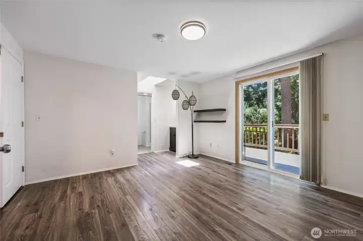 French doors lead to primary bedroom with slider to private balcony deck.
