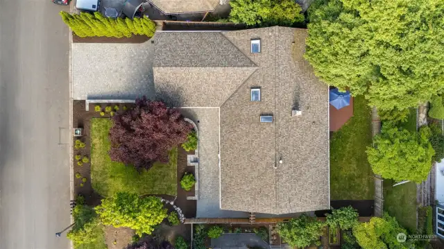 The aerial shows the care of the exterior including the roof, skylights, landscaping and attractive drive.