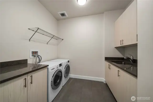 Laundry room with washer and dryer, storageroom with closet, sink and more storage.