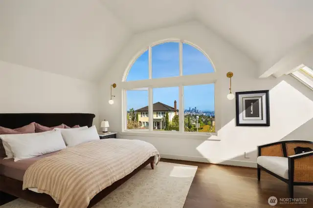 Generous in scale and bathed in southerly light, the primary suite wows with spectacular views framed by designer sconces.  As part of the current owners' updates, all of the prior wall-to-wall carpet was replaced with new hardwoods stained to match the walnut-toned main.