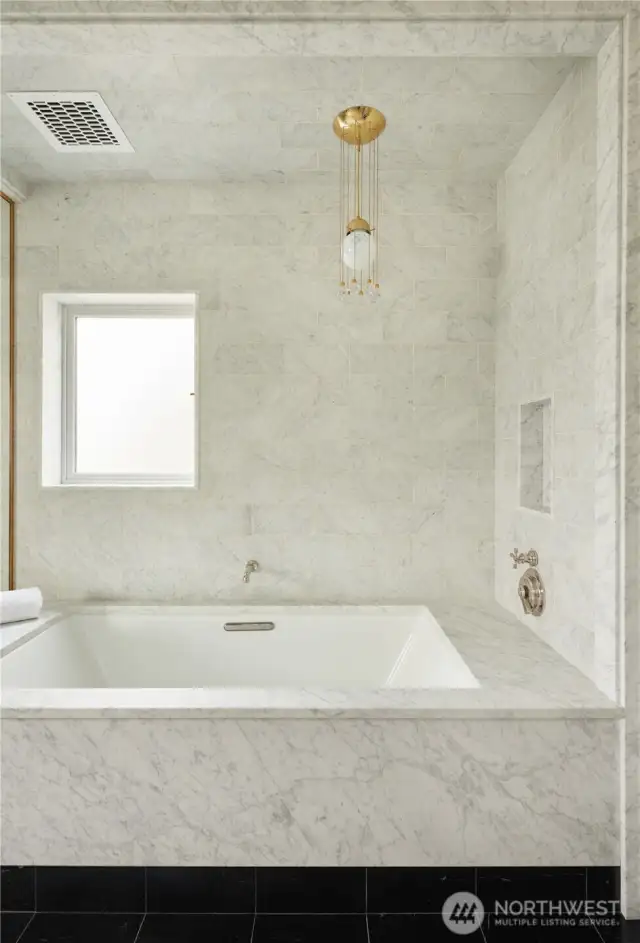 The stunning statement pendant hanging over the tub is an original Josef Hoffman design from the 1900's, imported from Austria.