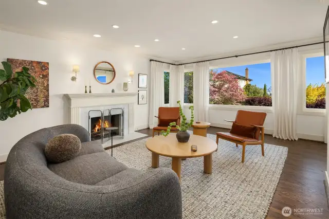 An Italian Carrara Marble fireplace surround was one of the many recent updates elevating this space, along with designer sconces and sumptuous wool window-coverings.