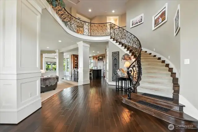 A spectacular grand entry with high ceilings, stylish iron stair railings, mocha hard wood flooring, and detailed craftsman style millwork!