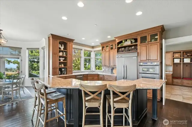 The gourmet kitchen is a chef’s dream, complete with granite slab countertops, a generous island, Kitchen Aid Pro Line stainless steel appliances, walk-in pantry, and custom cabinetry.