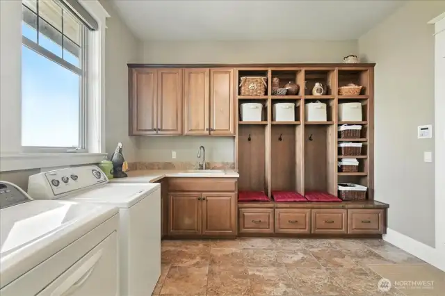 A large laundry room with sink and built-in cabinets.