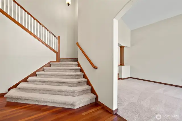 Front entryway with dramatic staircase. To left of shot is the coat closet