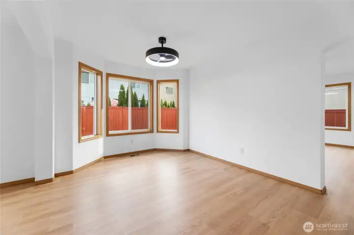 Spacious bay window surround formal dining space with newly installed LVP wood floors.