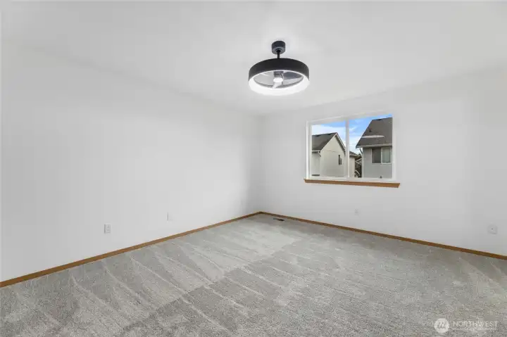 Primary Suite with new carpet and light fixture/fan.