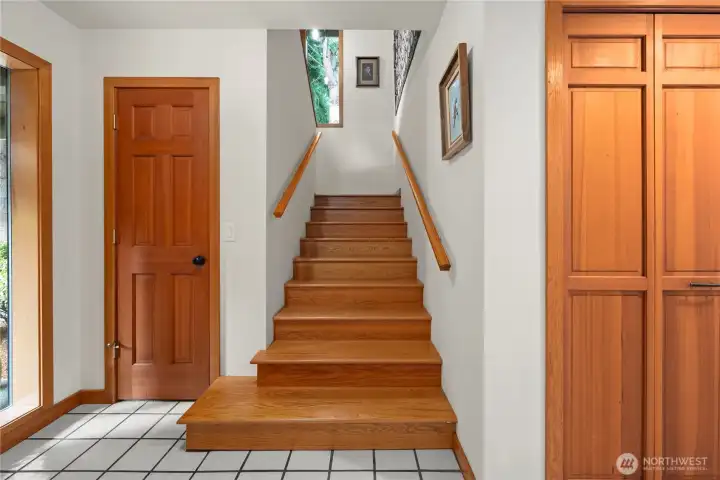 The wide gentle stairway boasts vaulted ceilings and large windows gathering in all the outdoor light.