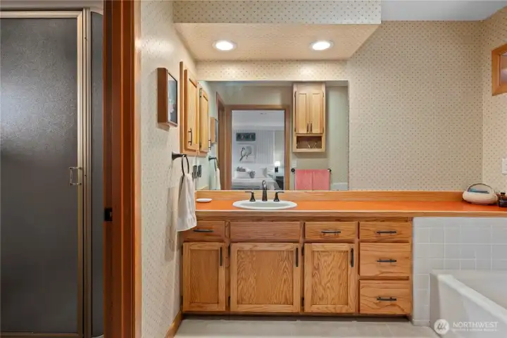 Large and lovely primary  en-suite. Solid wood cabinets. separate tub an shower.