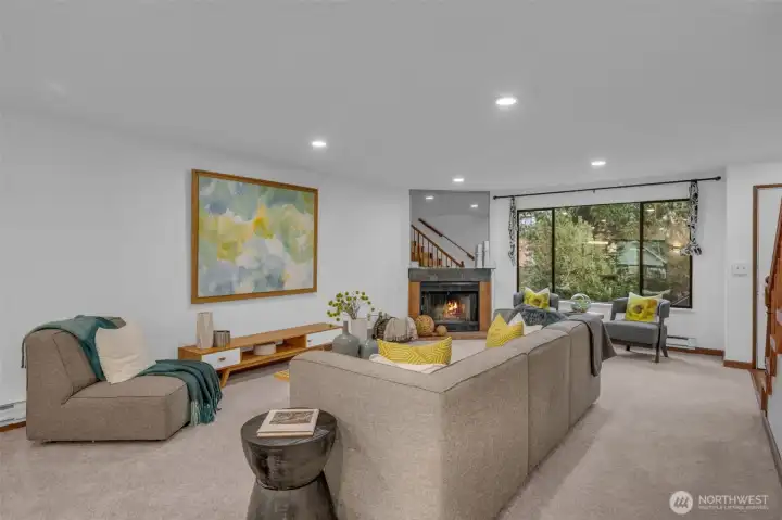 The living room lives large.  Can lighting, big picture window lots tons of light in and the wood burning fireplace ties the space together.