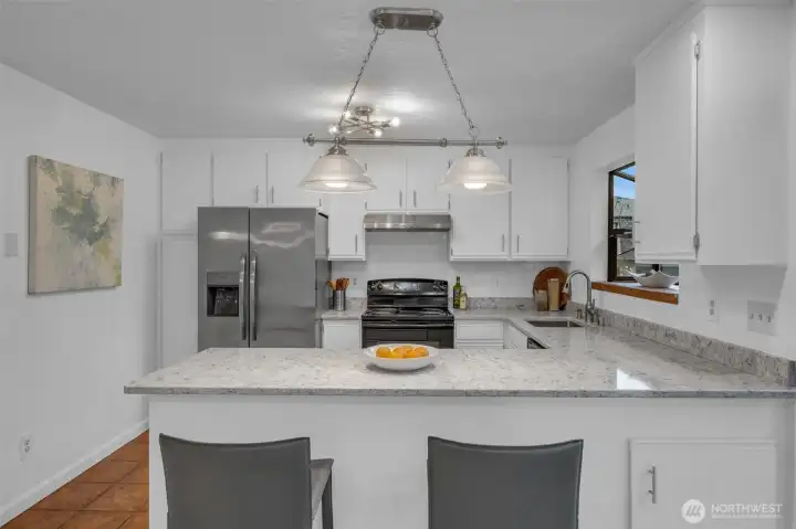 Great kitchen space for preparing meals. Lots of counter and cabinet space in this functional kitchen.  Deep stainless steel sink with garden window, new counters and subway tile backsplash. Dishwasher, stove, refrigerator with built in ice and water dispenser stay with.