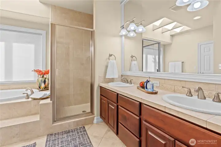 Dual sinks for extra space, a walk in shower for convenience and lovely tile work