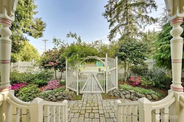 Looking out from the front porch illustrates the well cared for garden area when entering a home that brings reflection of an era so well deserving.