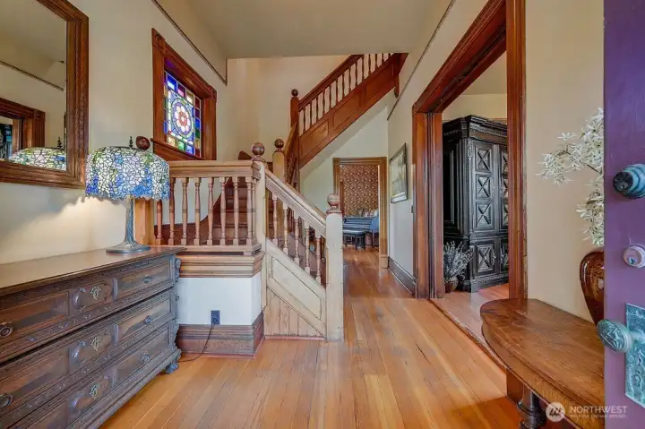Original millwork and a detailed staircase define the entry, connecting all three levels of this home.