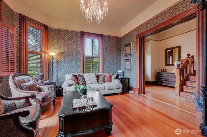 To the right of the entry, a living room with fireplace and original detail reflects the home's character.
