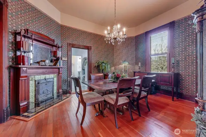 The dining room is defined by detailed ironwork, a classic chandelier, and original wood floors that carry throughout the home.