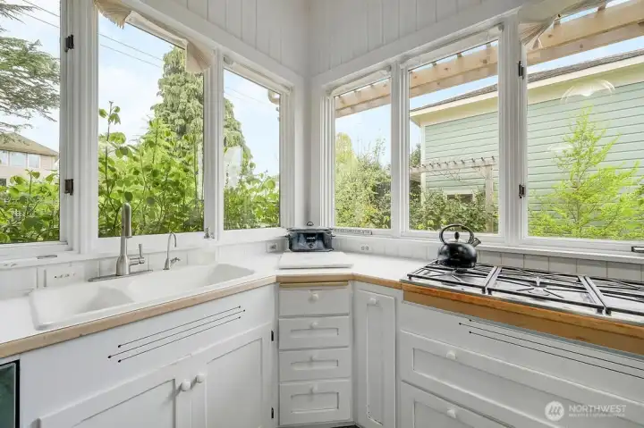 The kitchen opens to the backyard, with natural light and garden views.