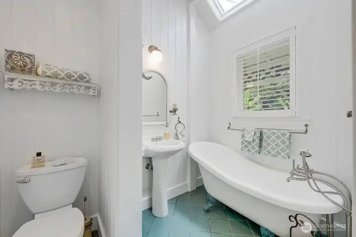 A clawfoot tub and a sink with traditional turn levers highlight the bath's period detail.