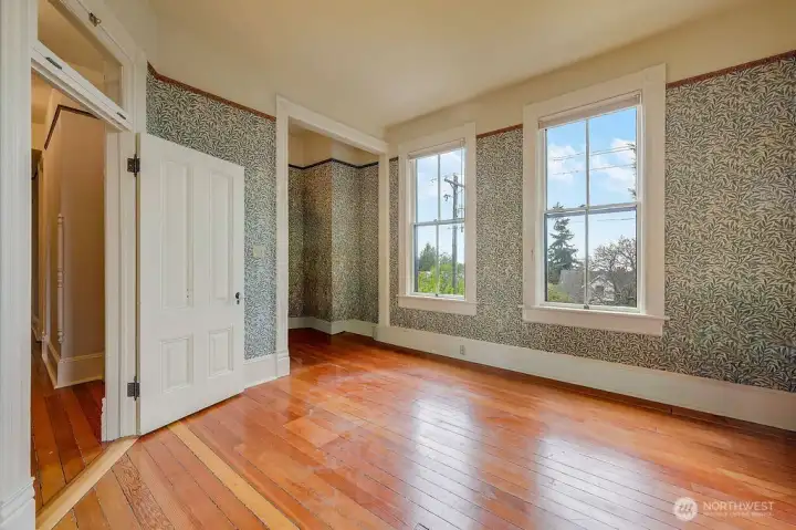 An upstairs bedroom with a transom window above the door, allowing light between rooms, with views toward Puget Sound.