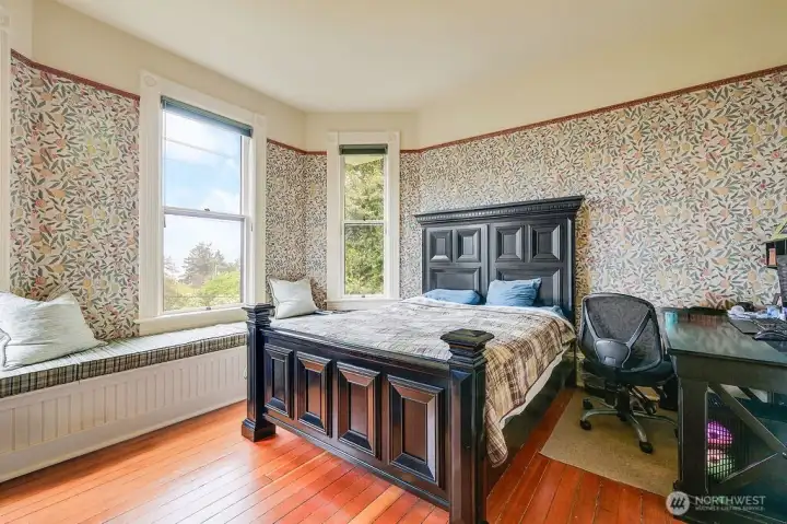 Another view of the bedroom, with original woods floors and the window seat.
