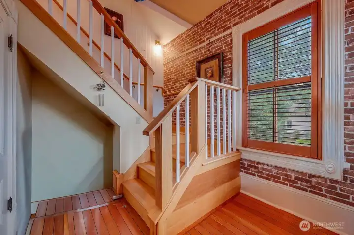 Stairwell leads to a top-floor room featuring an arched doorway.