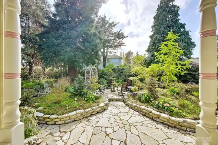From the back patio door, stonework leads to a raised seating area set within quiet garden surroundings.