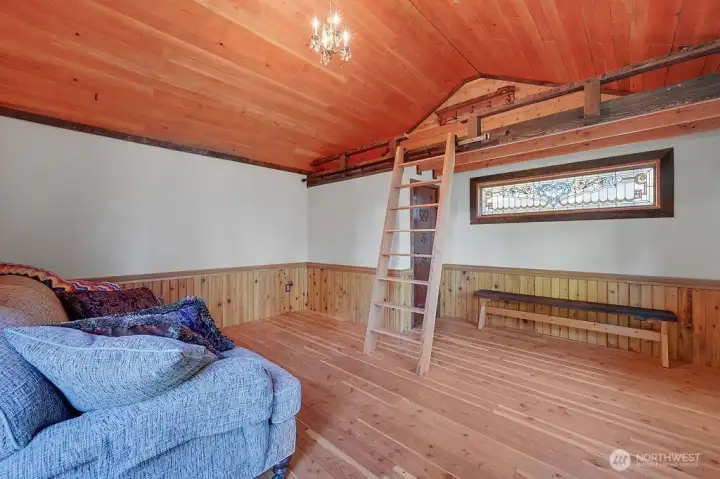 Light-filled interior with a ladder to access sleeping loft, finished with sustainable materials and suited for studio or retreat use.