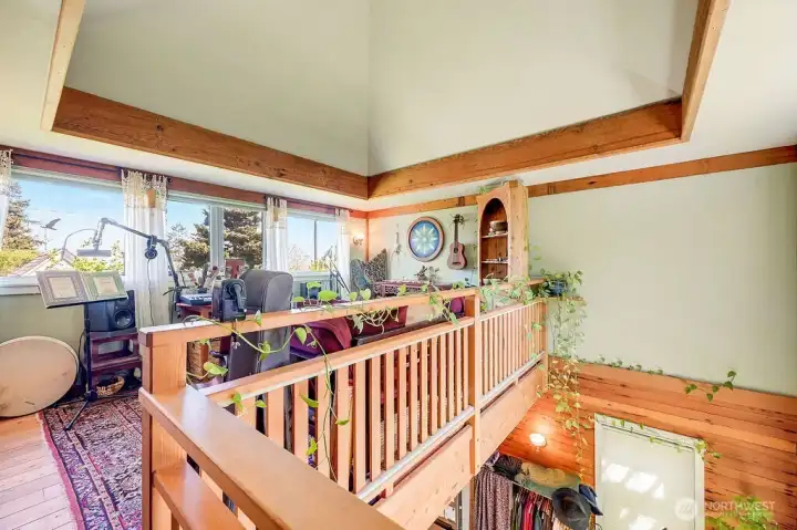 Loft area with open slat wood railing, brinigng in light and views.