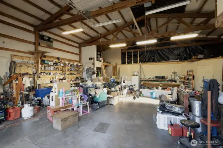 Expansive shop interior with woodstove and flexible loft potential.