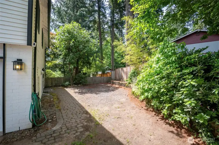 Gravel parking tucked back adjacent garage