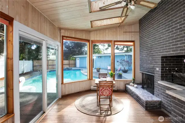 The sunroom with it's fireplace has a nice view of the back deck and the many windows let in so much natural light.