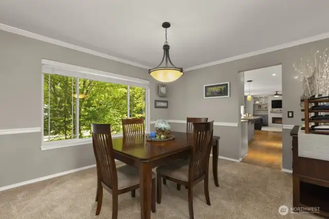 A generously sized dining room trimmed with stylish crown molding and classic chair rail.