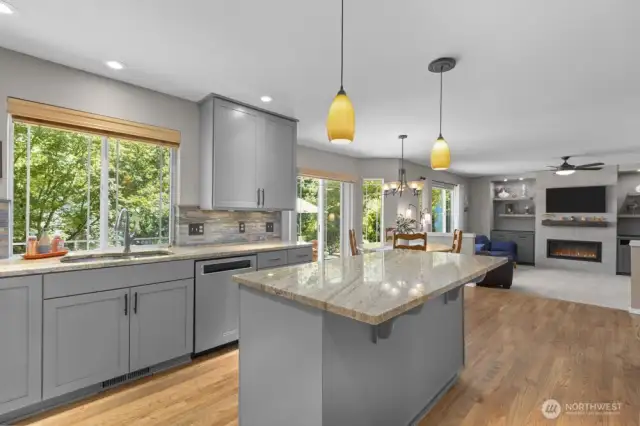 The kitchen and family room overlook a backdrop of lush greenery—bringing nature in and calm vibes all day long.