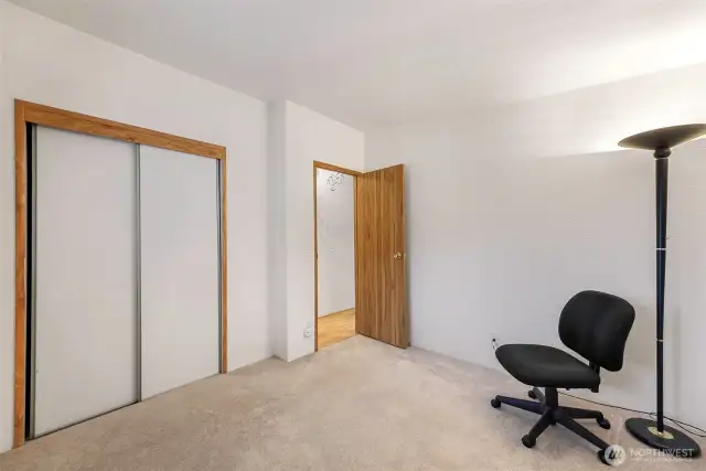 This secondary bedroom offers soft carpeting, neutral walls, and a large window—perfect for guests or home office needs near Lake Samish.