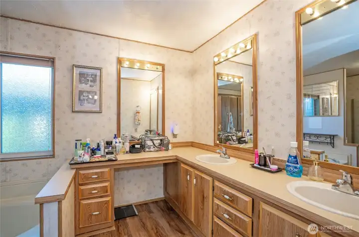 Beautifully appointed primary bath with double vanities and a makeup counter.