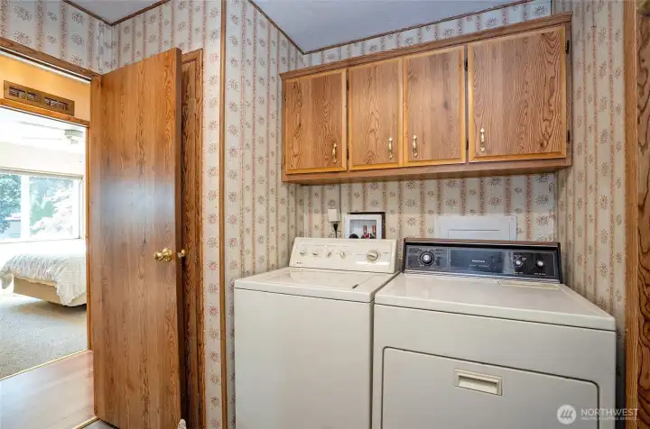 Convenient utility room with built-in cabinetry for extra storage.