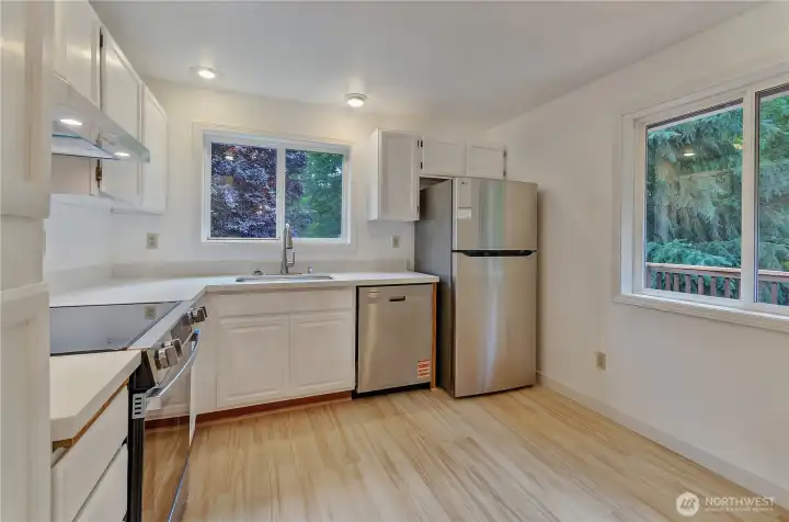 Updated kitchen with fresh cabinetry,  countertops, and newer appliances, plus a bright dining area and open living space.