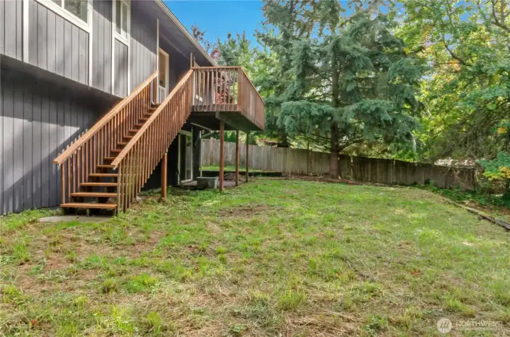 Spacious fenced backyard with a concrete patio & new deck.