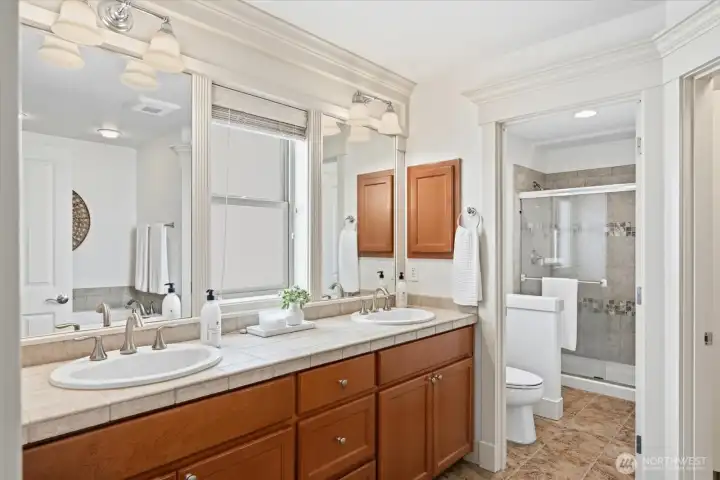 Luxurious Primary spa-inspired en-suite bath with dual vanities, soaking tub, and generous walk-in closet
