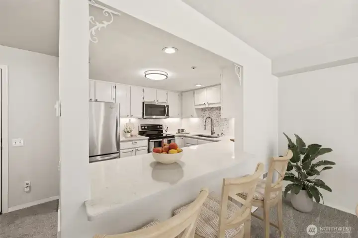 Bright, functional layout with breakfast bar & under-cabinet lighting. (Virtually Staged)