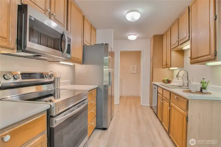 Kitchen/nook with new LVP flooring, newer SS appliances (new microwave), new sink faucet.